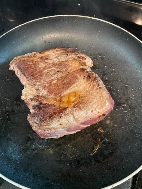 Chuck roast browning in a pan