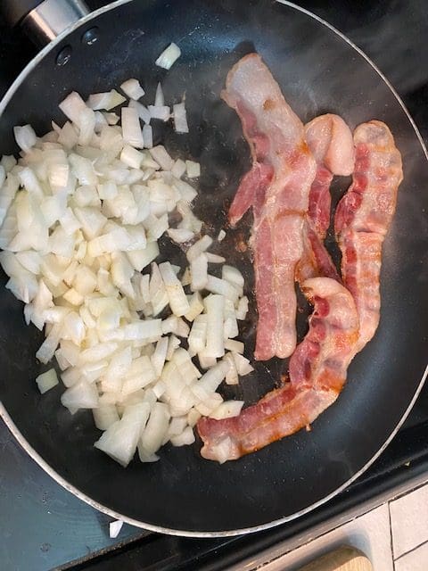 Beef in Barolo or Merlot, onion and bacon cooking.