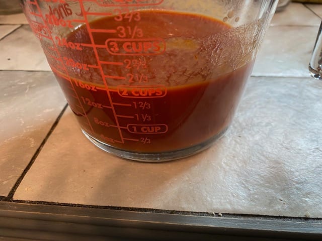 Tomato paste in a Pyrex measuring cup with water